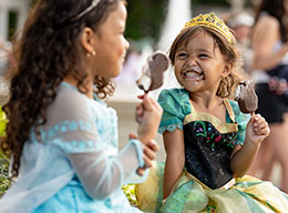 Girls in disney princess dresses eating ice cream
